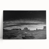 Stretched canvas wall art depicting a serene valley landscape with soft greens and blues, elegantly leaning against a neutral wall, perfect for home decor.