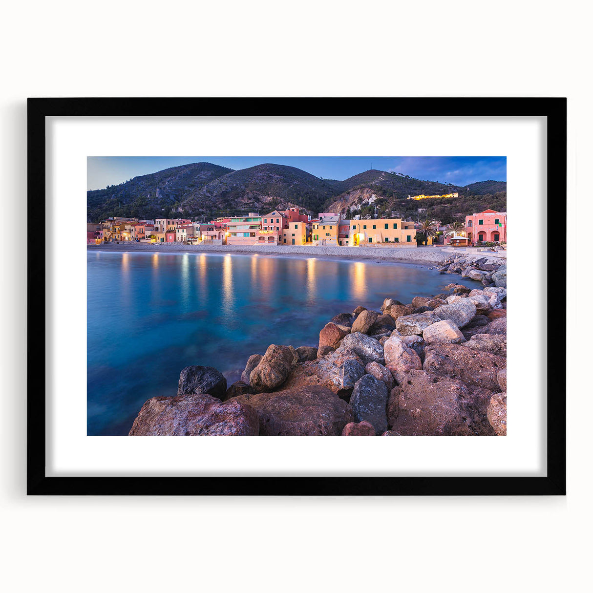 Framed wall art showcasing a serene village landscape design, featuring a black frame with a mat, ideal for enhancing home decor with a touch of elegance.