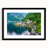 Framed wall art featuring a picturesque village landscape design with vibrant colors, set in a black frame with a white mat, ideal for home decor enhancement.