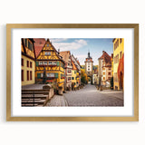 Framed wall art featuring a picturesque landscape of charming villages, with a gold mat and frame highlighting the serene scenery, perfect for home decor.
