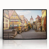 Framed acrylic wall art displaying a scenic landscape of a quaint village, featuring vibrant colors and intricate details, perfect for home decor and enhancing interior spaces.