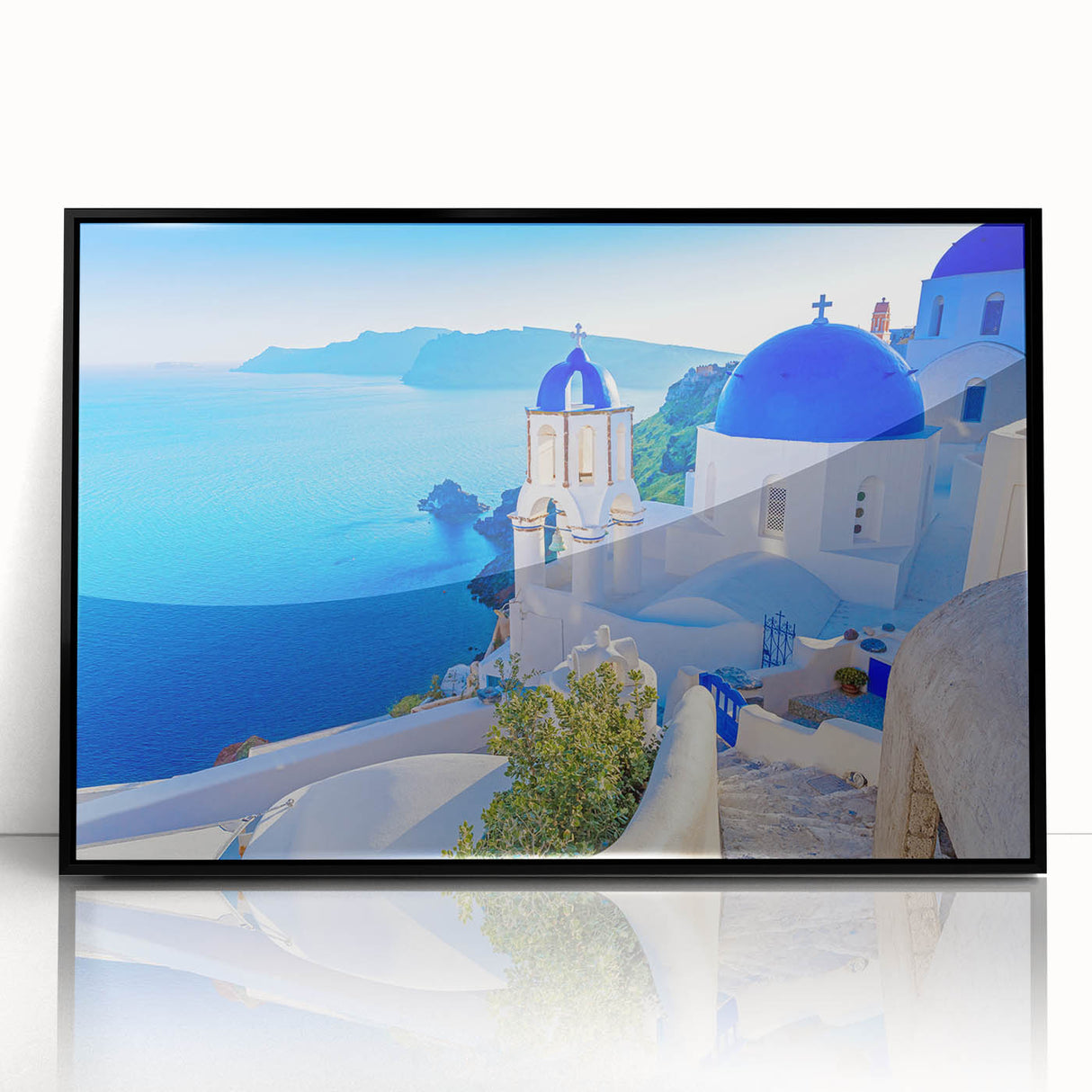 Framed acrylic wall art featuring a serene village landscape design, highlighting lush greenery and quaint houses, presented in a sleek black frame for modern decor.