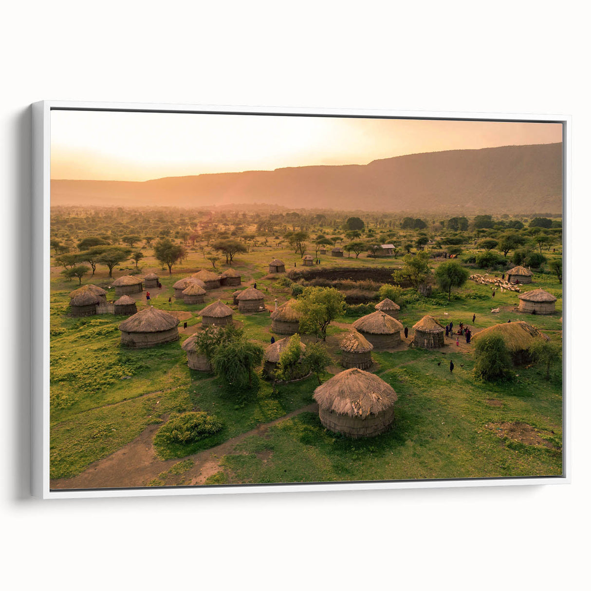Framed canvas wall art depicting a serene landscape with quaint villages, featuring vibrant colors and intricate details, showcased from a side view against a white background.