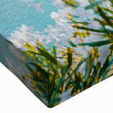 Close-up of a vibrant stretched canvas wall art piece depicting a serene village landscape with rich colors and intricate details, ideal for home decor.