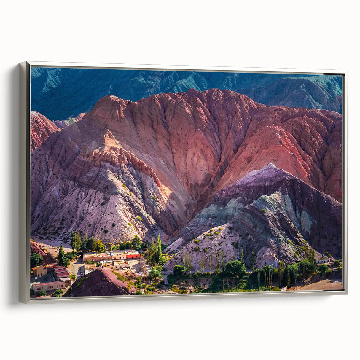 Framed canvas wall art showcasing a serene village landscape with vibrant colors, silver frame, and a contemporary design, perfect for home decor.