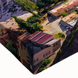 Close-up of a vibrant stretched canvas wall art showcasing a picturesque village landscape with rich colors and intricate details, perfect for home decor.