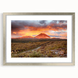 Framed landscape wall art featuring a vibrant volcano design in rich colors, set in a sleek silver frame with a white mat, ideal for home decor.