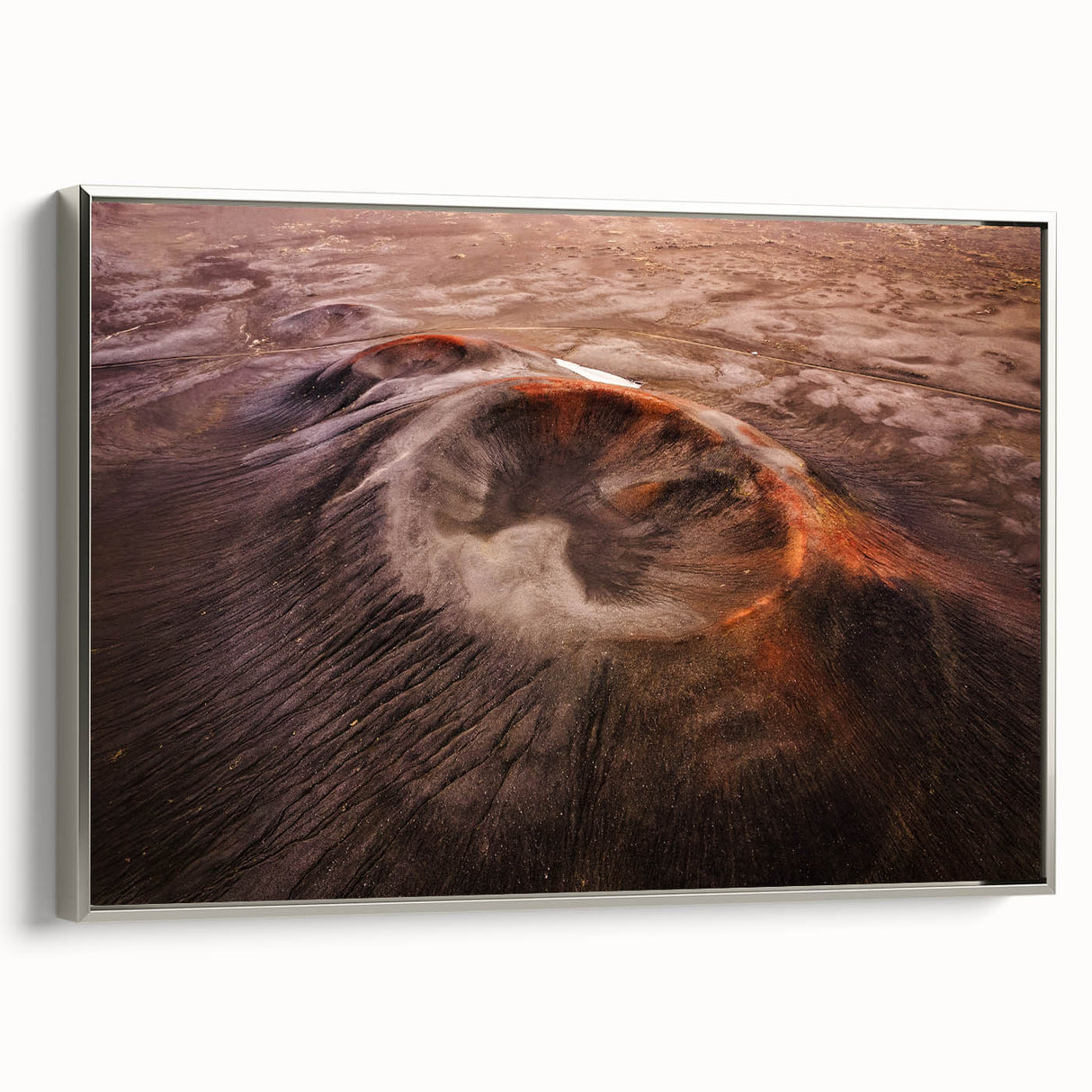 Framed canvas wall art showcasing a vibrant volcano landscape design, featuring rich colors and dynamic textures, elegantly displayed with a sleek silver frame.