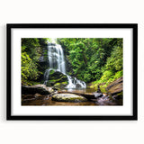 Framed wall art depicting a serene waterfall landscape design, featuring vibrant blues and greens, set in a sleek black frame with a white mat, perfect for home decor.