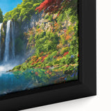 Framed canvas wall art featuring a vibrant waterfall landscape with lush greenery and soft flowing water, adding serenity and color to any space decor.