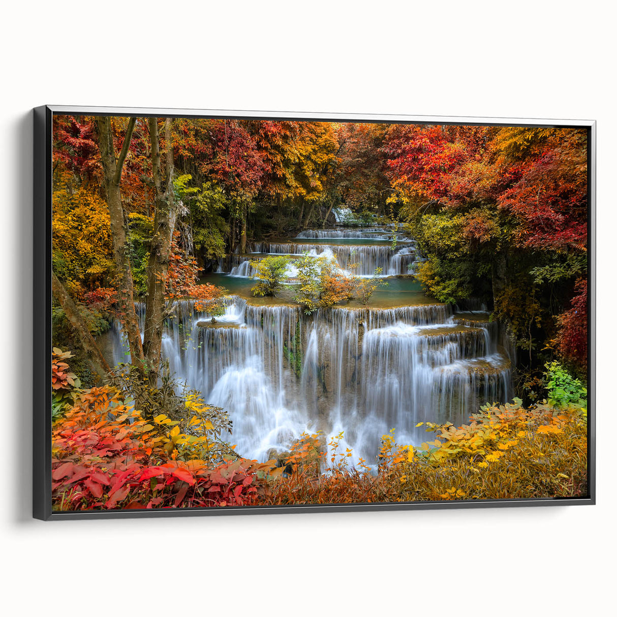 Framed canvas wall art showcasing a serene waterfall landscape in vibrant colors, featuring a black frame and side view to highlight its elegant design and depth.
