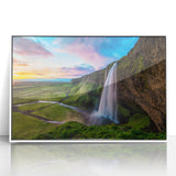 Framed acrylic wall art depicting a vibrant waterfall landscape, featuring lush greenery and flowing water, set in a sleek white frame, ideal for home decor.