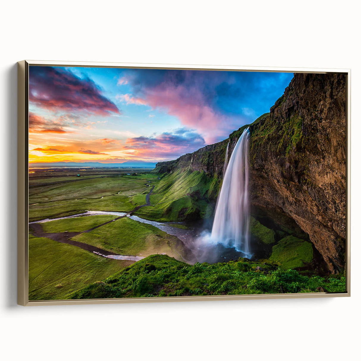 Framed canvas wall art showcasing a serene waterfall landscape with vibrant greens and blues, accented by a luxurious gold frame, ideal for home decor.