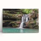 Stretched canvas wall art depicting a vibrant waterfall landscape with lush greenery and a serene blue sky, perfect for nature-themed decor in living spaces.