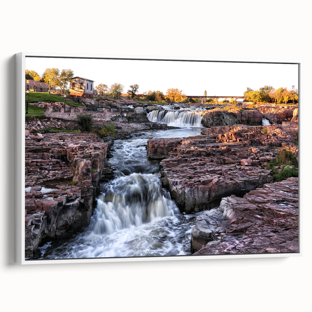 Framed canvas wall art showcasing a serene waterfall landscape design, featuring vibrant blues and greens, displayed in a white frame from a side view, perfect for enhancing home decor.