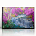 Framed wall art featuring a stunning waterfall landscape design, showcasing vibrant blue water cascading down rocky cliffs, set in a sleek black frame for elegant decor.