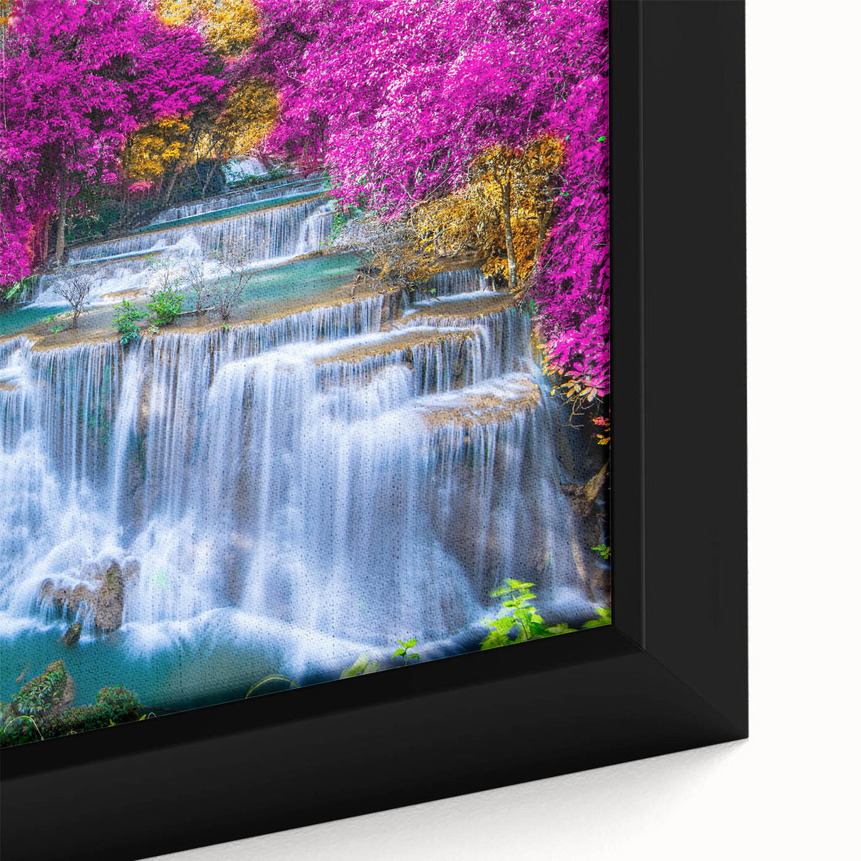 Close-up of a framed canvas wall art piece showcasing a vibrant waterfall surrounded by lush greenery, perfect for nature-themed home decor. The intricate details and rich colors enhance the serene and calming atmosphere, making it an ideal addition to any living space or office.