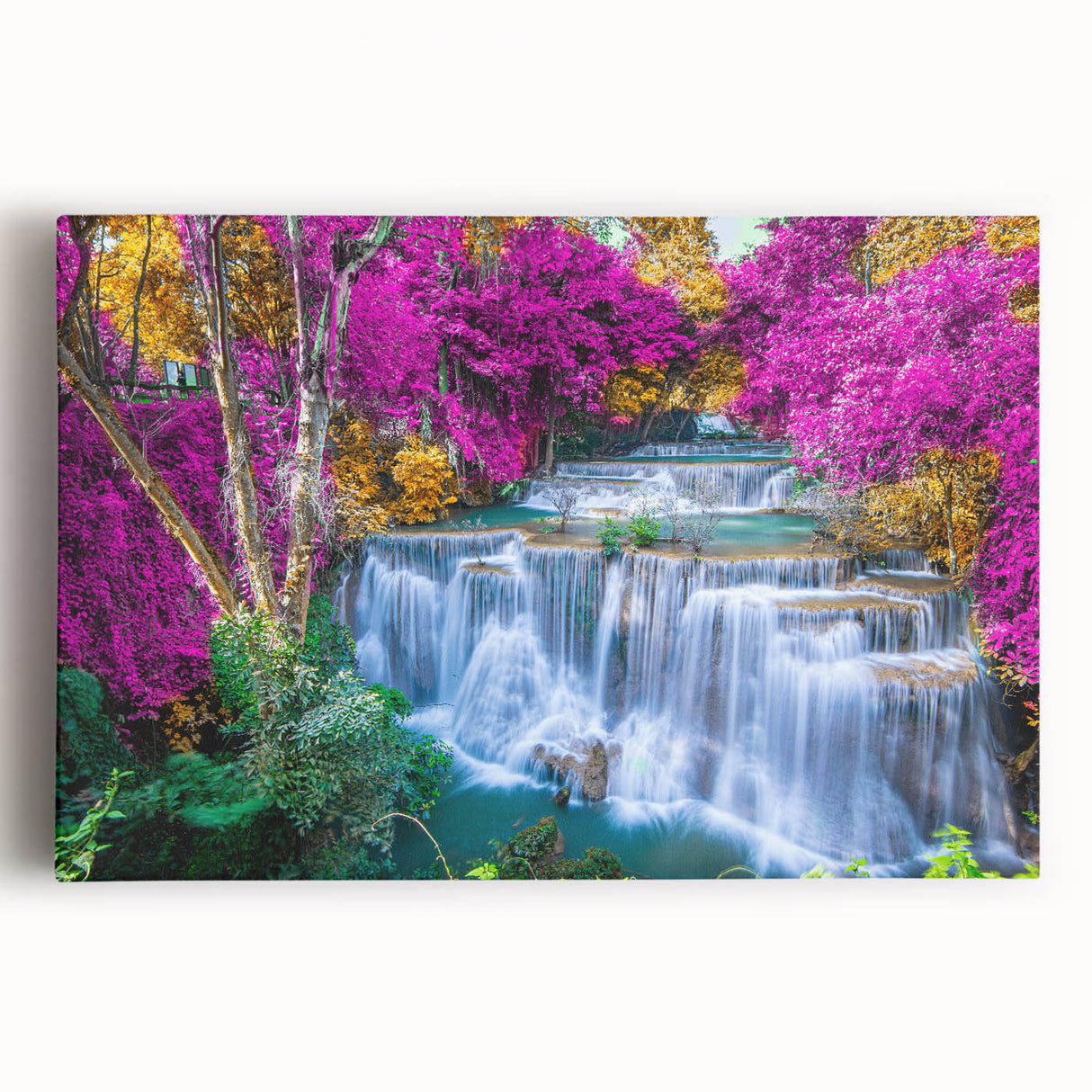 Stretched canvas wall art depicting a serene waterfall landscape, vibrant blue water cascading over rocks, surrounded by lush green foliage, perfect for home decor.