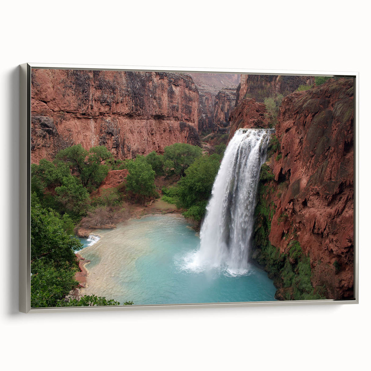 Framed wall art featuring a serene waterfall landscape design with vibrant blues and greens, elegantly bordered in silver, perfect for home decor enhancement.