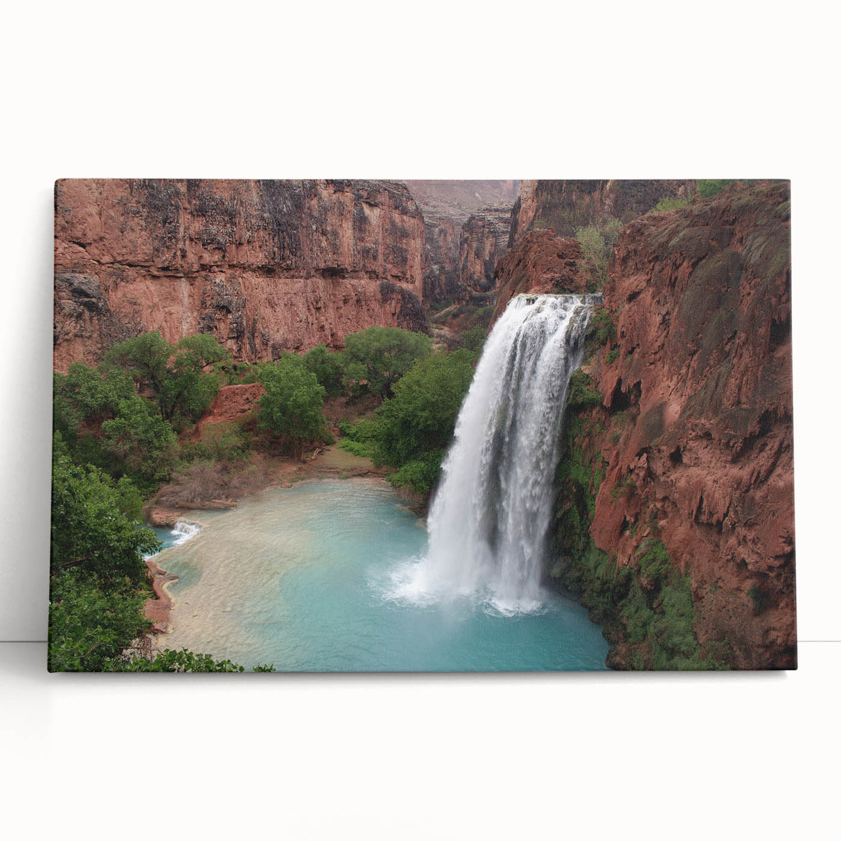 Stretched canvas wall art depicting a serene landscape with a cascading waterfall surrounded by lush greenery, perfect for enhancing home decor and creating a calming atmosphere.