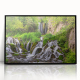 Framed acrylic wall art showcasing a vibrant waterfall landscape design in a black frame, perfect for enhancing home decor and adding a touch of nature.