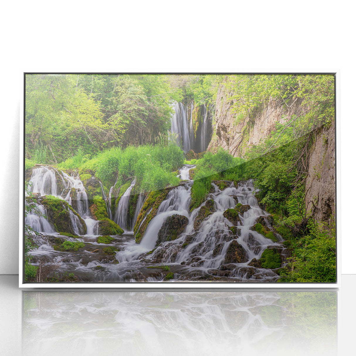 Framed acrylic wall art featuring a serene landscape with a cascading waterfall, surrounded by lush greenery. The design enhances any modern home decor aesthetic.