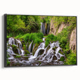 Framed canvas wall art showcasing a serene waterfall landscape with lush greenery, presented in a sleek black frame, ideal for home decor enhancement.