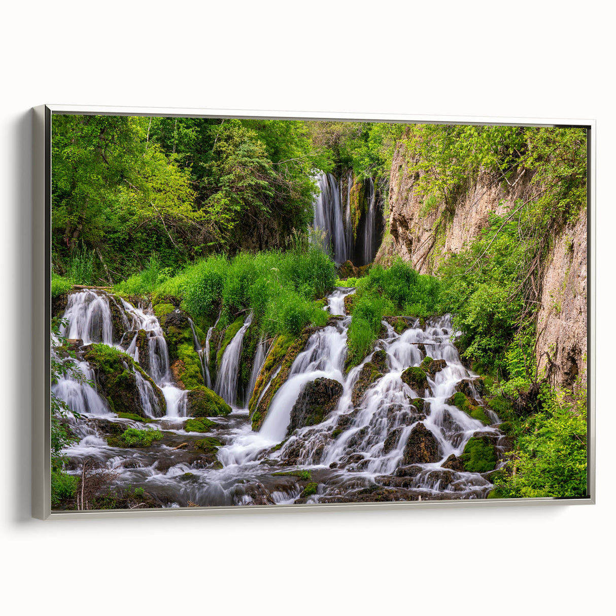 Framed canvas wall art showcasing a serene waterfall landscape design with silver accents, perfect for enhancing modern home decor. The artwork captures vibrant colors and natural beauty, providing a calming focal point for any room.