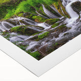 Serene landscape featuring a breathtaking waterfall cascading down rocky cliffs, surrounded by lush green foliage, perfect for home decor or nature-inspired art.