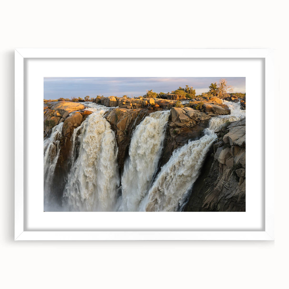 Framed wall art featuring a serene landscape of a cascading waterfall, set in a sleek white frame with a mat, perfect for enhancing home decor and creating a calming atmosphere.