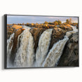Framed canvas wall art showcasing a serene waterfall landscape design, featuring vibrant blues and greens, with a stylish black frame enhancing its elegance. Perfect for home decor or office settings.
