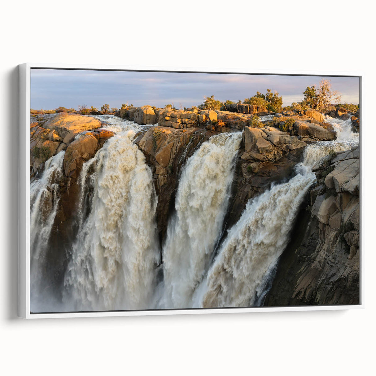 Framed canvas wall art showcasing a vibrant waterfall landscape design, featuring rich colors and detailed textures, displayed from a white side view in a modern setting.