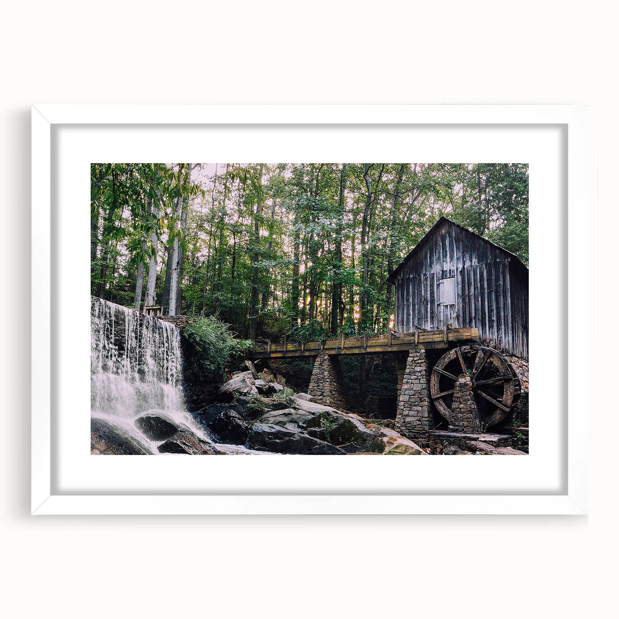 Framed wall art featuring a serene watermill landscape design, surrounded by a white mat, showcasing nature's tranquility and rustic charm. Perfect for home decor.