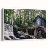 Framed canvas wall art showcasing a serene watermill landscape design in soft hues of blue and green, presented in a sleek white frame for modern decor.