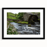Black-framed wall art featuring a serene landscape of a watermill, showcasing vibrant colors and intricate details, ideal for home decor and art enthusiasts.