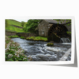 Rolled art print showcasing a serene landscape featuring a picturesque watermill surrounded by lush greenery and vibrant wildflowers, perfect for home decor.