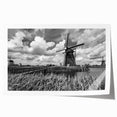 Rolled print showcasing a vibrant landscape with windmills, featuring a colorful sunset sky, perfect for home decor or art collections, packaged securely in a cardboard tube.