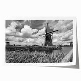 Rolled print showcasing a vibrant landscape with windmills, featuring a colorful sunset sky, perfect for home decor or art collections, packaged securely in a cardboard tube.