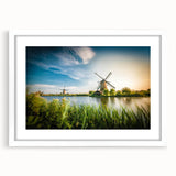 Framed wall art collection showcasing a serene landscape with windmills, featuring a white mat and sleek frame, ideal for home decor. Perfect for adding a touch of tranquility to any room.