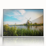 Framed acrylic wall art showcasing a picturesque landscape with windmills, featuring a white frame and vibrant colors, perfect for home decor enhancement.