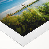 Rolled canvas wall art showcasing a serene landscape with windmills against a vibrant sunset, perfect for home decor. Features rich colors and detailed design.