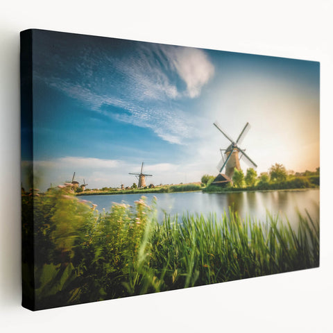 Stretched canvas wall art showcasing a serene landscape with windmills under a vibrant sunset, perfect for adding a tranquil touch to home decor.