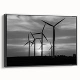 Framed canvas wall art featuring a serene landscape with windmills, set against a vibrant sunset. The artwork is displayed in a sleek black frame, adding elegance to any room decor.