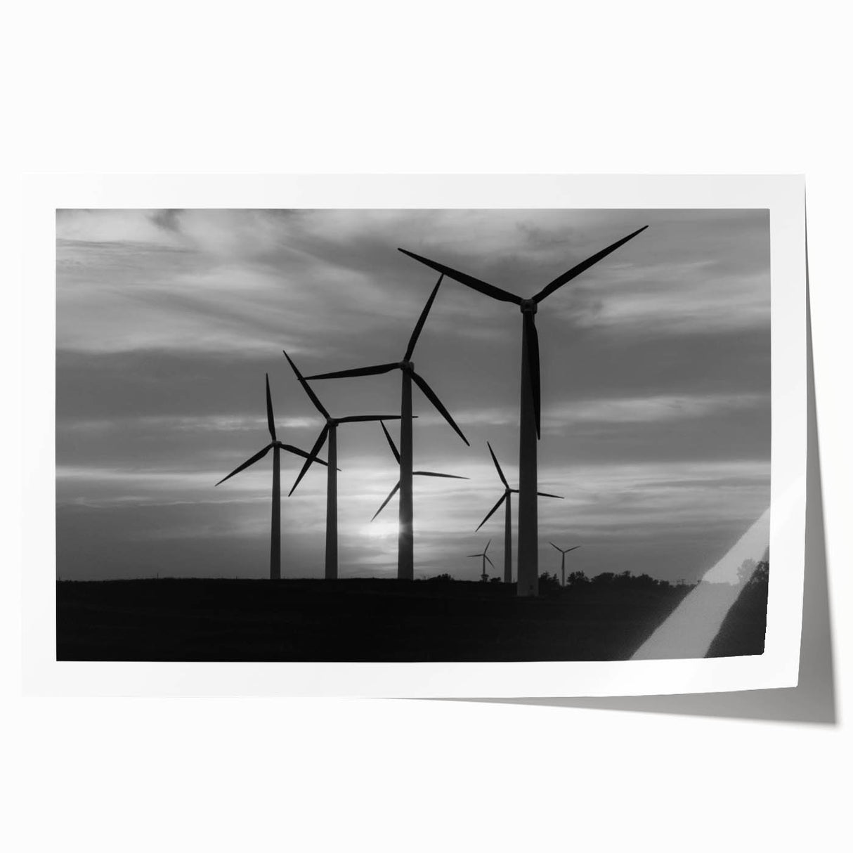 Rolled print of a scenic landscape featuring windmills against a vibrant sunset sky, perfect for home decor, showcasing rich colors and fine details.