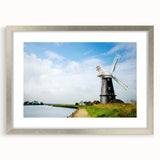 Framed wall art collection featuring a serene landscape with windmills in soft pastel colors, elegantly displayed with a silver mat and frame, ideal for home decor.