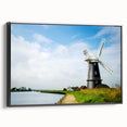 Framed canvas wall art showcasing a serene landscape with windmills, set against a vibrant sunset. Black frame enhances the visual impact, perfect for home decor.