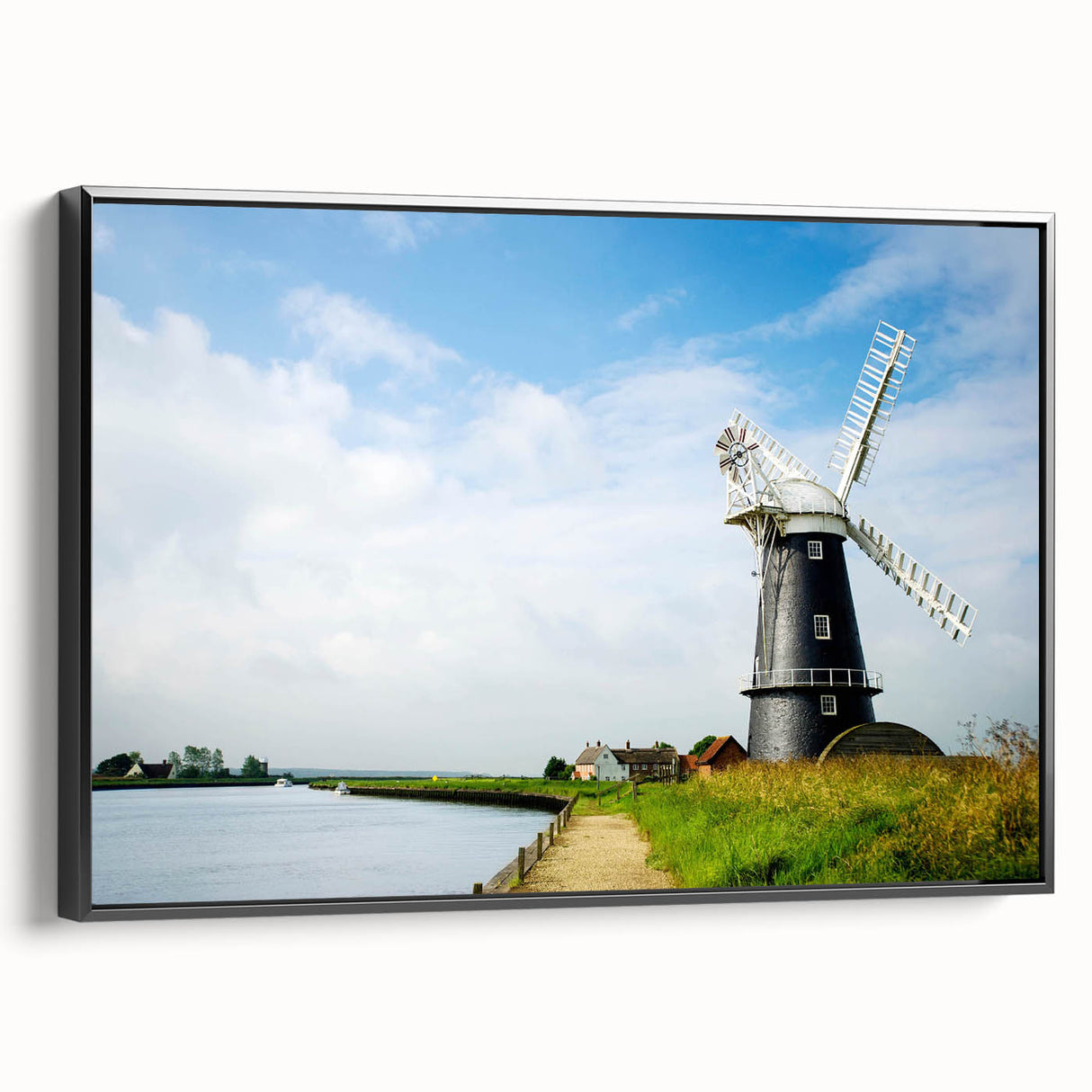 Framed canvas wall art showcasing a serene landscape with windmills, set against a vibrant sunset. Black frame enhances the visual impact, perfect for home decor.