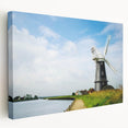 Stretched canvas wall art showcasing a vibrant landscape with windmills, featuring soft blue skies and lush green fields, perfect for home decor enhancement.