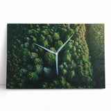 Stretched canvas wall art showcasing a scenic landscape with windmills against a vibrant sunset, leaning against a neutral wall, perfect for home decor.