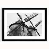 Framed wall art featuring a serene landscape with windmills, showcased in a sleek black frame with matting, perfect for enhancing modern home decor.